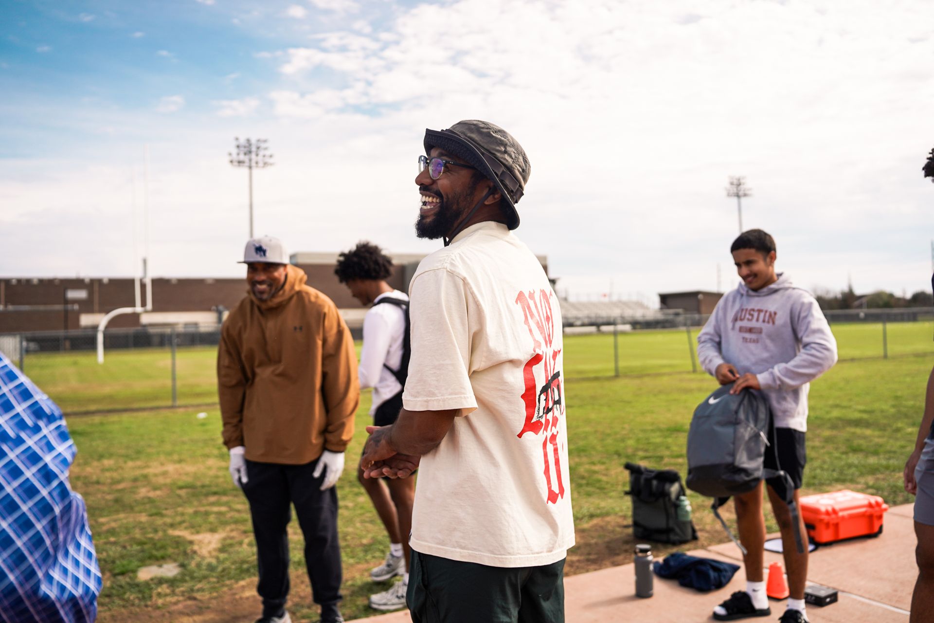 Coach TJ Hart laughing with athletes during a training session