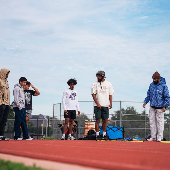 TJ Hart coaching a group of athletes on the field